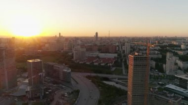 Günbatımında Summer City 'nin hava aracı görüntüsü. Bazı evler inşa edildi, bir ev hala yapım aşamasında. Arabalar yolda gider..