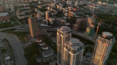 Akşam şehrindeki gökdelenlerin hava görüntülerine göre gün batımında önemli bir yerleşim bölgesinde. Arka planda modern şehir. Çatıdaki ve partideki insanlar