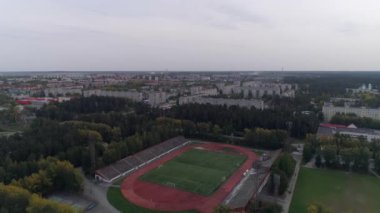 Futbol stadyumunun havadan görünüşü. Küçük kasabadaki sekiz sıkıcı apartman ve sarı-yeşil orman. İnsanlar stadyumda futbol oynuyor ve spor yapıyorlar. Rusya, En İyi Şehir