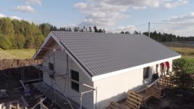 İnşaat alanının havadan görüntüsü. İşçilerin köpük bloğu bir katlı evi nasıl kapladığını görebilirsiniz. Evin çatısı metalden yapılmıştır.