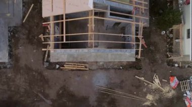 İnşaat alanının yukarıdan aşağıya doğru görüntüsü. Evin nasıl inşa edildiğini görebiliyorsunuz. İnsansız hava aracı, çatısı olmayan bir evin üzerinde uçuyor.
