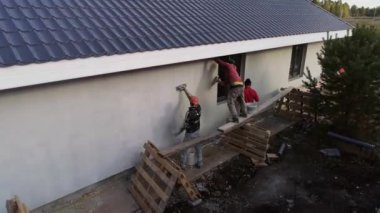 İnşaat alanının havadan görüntüsü. İşçilerin köpük evi nasıl kapladığını görebilirsiniz. Evin çatısı metalden yapılmıştır.