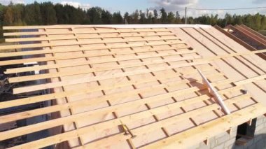 İnşaat alanının havadan görüntüsü. Evlerin nasıl inşa edildiğini görebilirsiniz. Kamera evin çatısına doğru uçar. Sadece Çatı Çerçevesi Yapımı var.