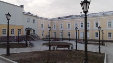 İdari binanın yenilenmiş yeni avlu manzarası (okul, spor salonu, enstitü) banklar, fenerler, çiçek yatakları ve kaldırım döşemeleri ile