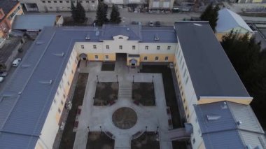 İdari binanın yenilenmiş yeni avlusuna (okul, spor salonu, enstitü) banklar, fenerler, çiçek yatakları ve kaldırım döşemeleri ile hava manzarası