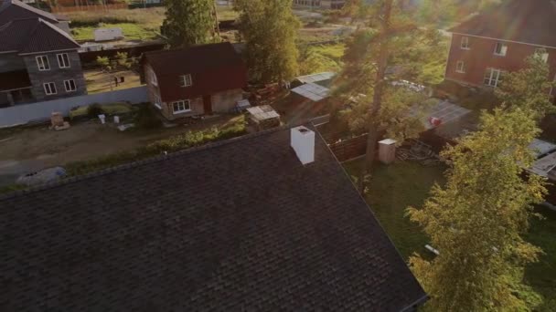 屋檐的空中俯瞰 屋檐由带有烟囱的软瓷砖制成 新的现代化住宅2层房子小屋在一个不错的社区 地上长满了树和草坪 — 图库视频影像