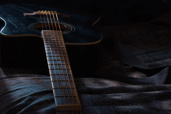 Guitar laying in dark room with moonlight shining on it — Stock Photo, Image