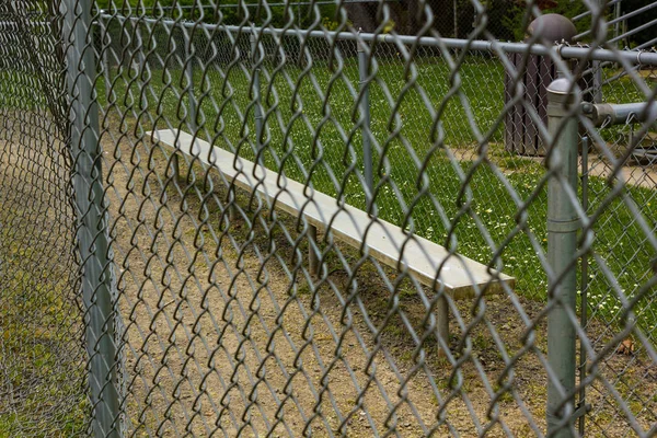 Fence and bench at baseball field at park — Stock Photo, Image