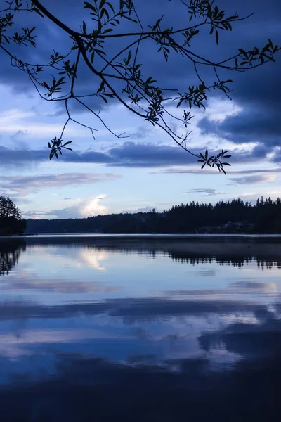 Озеро под облаками в сумерках — стоковое фото