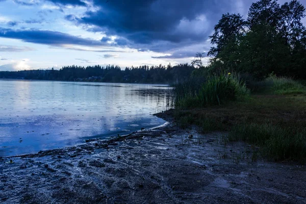 Rive sombre du lac sous le ciel bleu — Photo