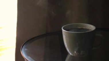 Bir cam yüzey üzerinde dumanı tüten kahve