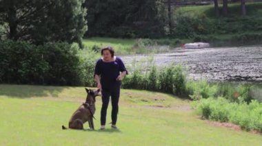 Kadın köpekle oynuyor.