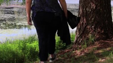 Kız Gölü yakınındaki ağacın altında oturuyor