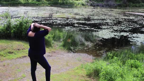 Femme jouant avec les cheveux par lac — Video