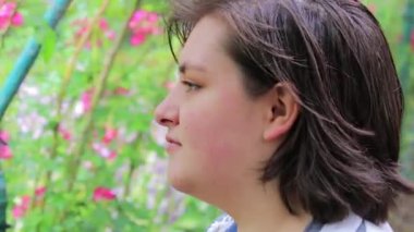 gül bahçesinde kız etrafına bakıyor ve gülümsüyor