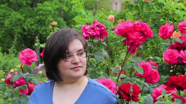 Girl with glasses in front of roses — Stock Video