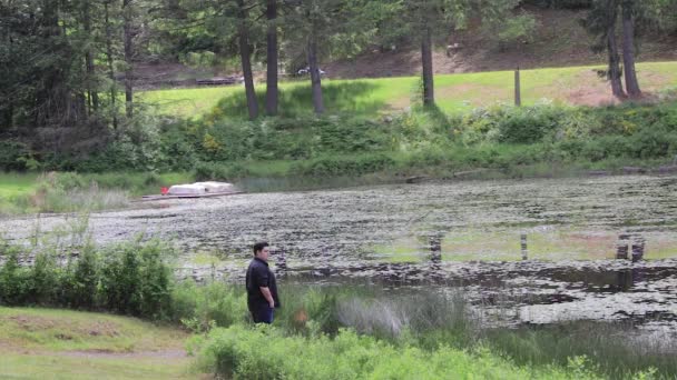 Хлопець дивиться спокійно над озером — стокове відео