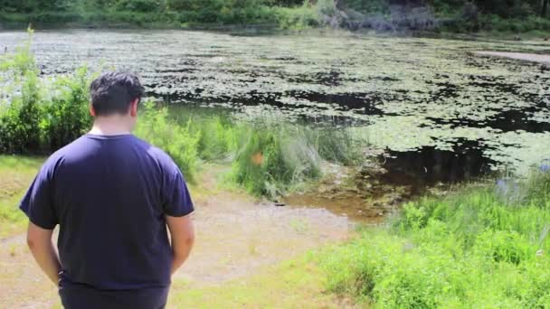 Gars marchant près du lac — Video