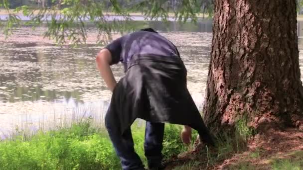 Guy zittend onder een boom — Stockvideo