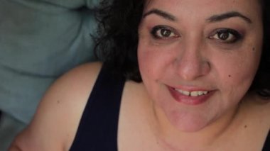 mavi bir sandalyede gülümseyen kadın