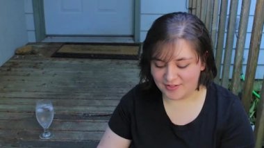 Kamera arkasında birine söz sundurma adım üzerinde oturan bir kadın