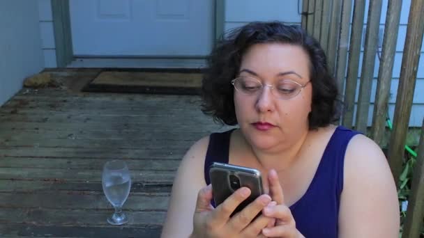 Kvinna med telefon på veranda — Stockvideo
