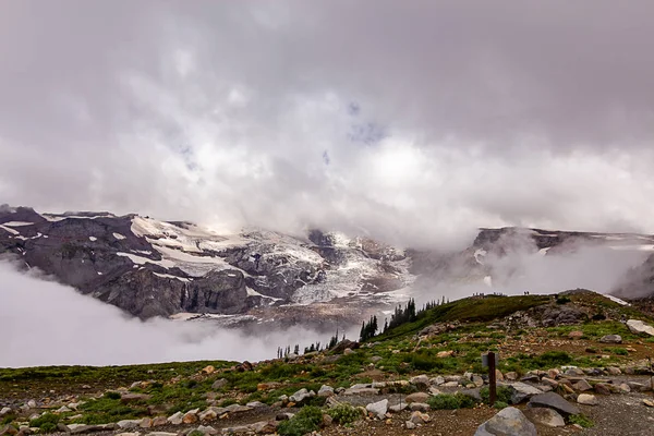 Densas nuvens brancas cobrindo montanha nevada — Fotografia de Stock