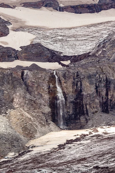 Καταρράκτη το καλοκαίρι μακριά από ένα βράχο καλύπτεται σε παγετώνες — Φωτογραφία Αρχείου
