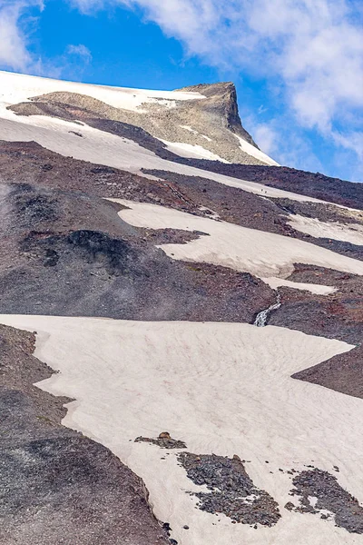 Снігові поля вздовж скелястого гірського піку — стокове фото