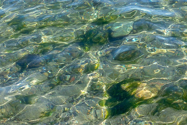 Shiny teal and gold reflections in water — Stock Photo, Image