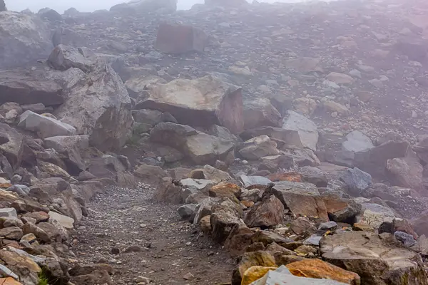 Aspro sentiero di pietra e ghiaia per escursioni in nebbia e nuvole — Foto Stock