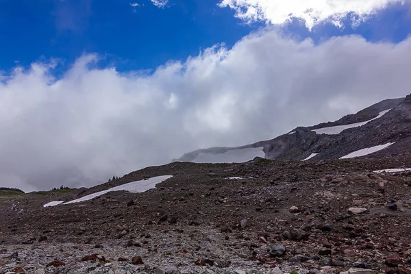 Puszyste białe chmury nad snowy mountain — Zdjęcie stockowe