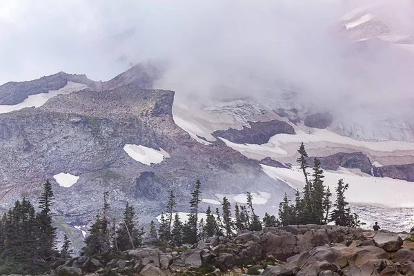 Chmury nad snowy mountain za sosny — Zdjęcie stockowe