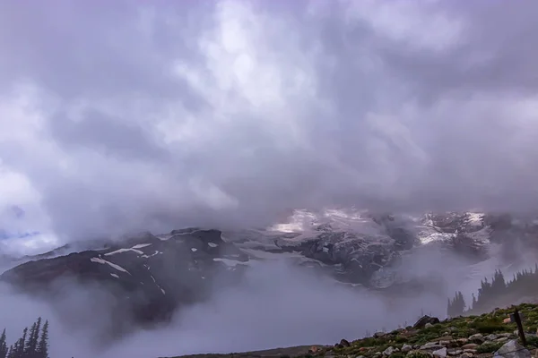 Tall mount of mountain top hidden by clouds and mist — Stock Photo, Image