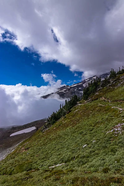 Шари пухнастих білих хмар, що рухаються над горою — стокове фото