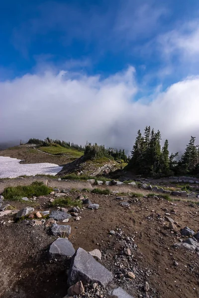 Stezka vedoucí dolů hory bílý načechraný mraky — Stock fotografie