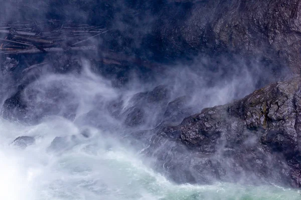 Donkere rock en white water van de waterval shapes maken en nevel in de lucht — Stockfoto