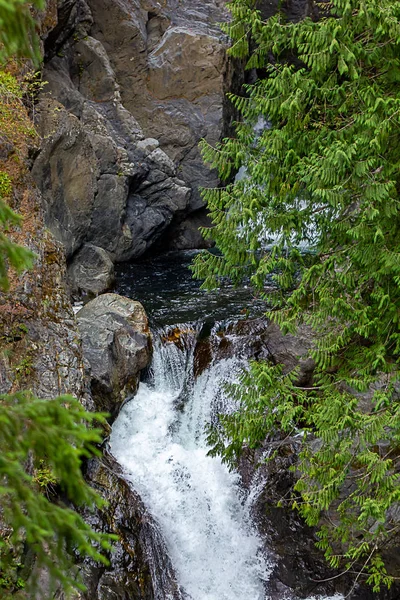 In Felswand gehauen und Pflanzen lassen Wasserfall entweichen und fallen — Stockfoto