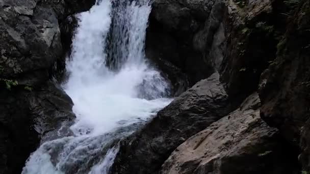 Capas de agua cayendo sobre oscuros charcos profundos de piedra — Vídeos de Stock