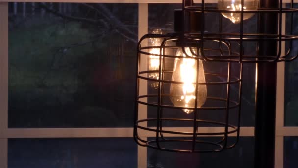 Лампа відображається у вікні з вечірнім снігом позаду — стокове відео