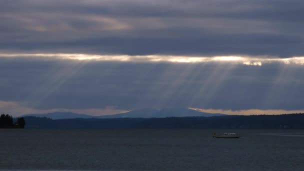 Puget Sound mit Wolken über dem Wasser und Lichtstrahlen, die auf das Boot herabkommen — Stockvideo