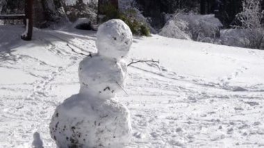 karlı parkta güneş parlar gibi yan eğiliyor çarpık kar adam
