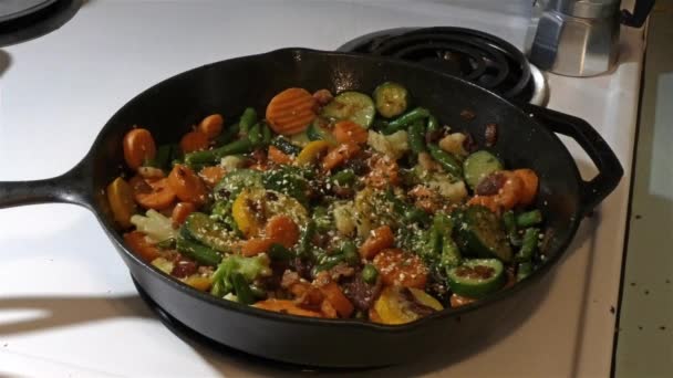 Seasoning chopped vegies in bubbling oil — Stock Video