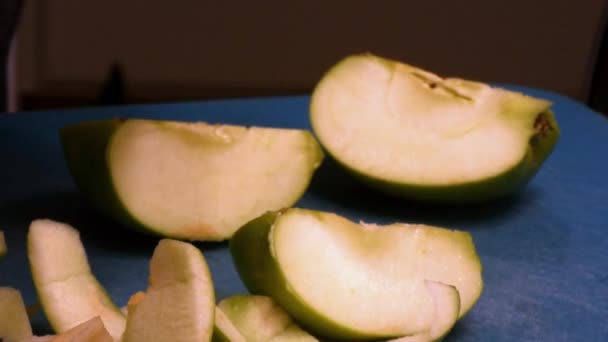Пилинг гри яблоки на голубой доске резки — стоковое видео