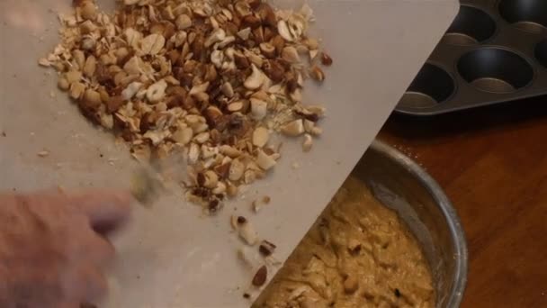 Añadir nueces mezcladas en la masa de magdalenas — Vídeo de stock