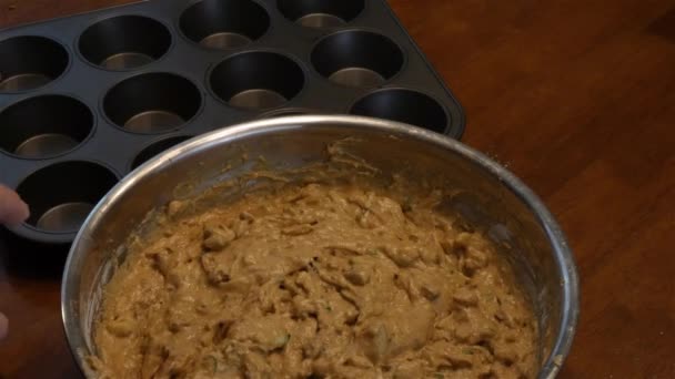 Womans hand places cupcake liners in tin for baking muffins — Stock Video