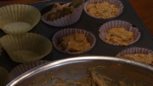 Lepels schep beslag in kleurrijke muffins — Stockvideo