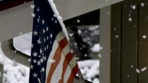 Tormenta cubre lentamente bandera americana en nieve — Vídeos de Stock