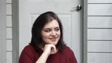 Genç kadın kamera kapalı birine bakıyor ve gülümsüyor