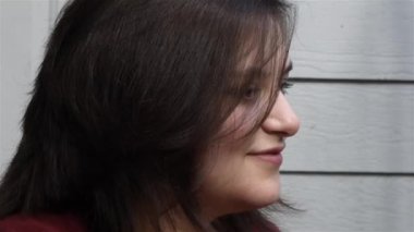 Genç kadın fırçalar saç dışarı yüz ve smirks içinde kamera